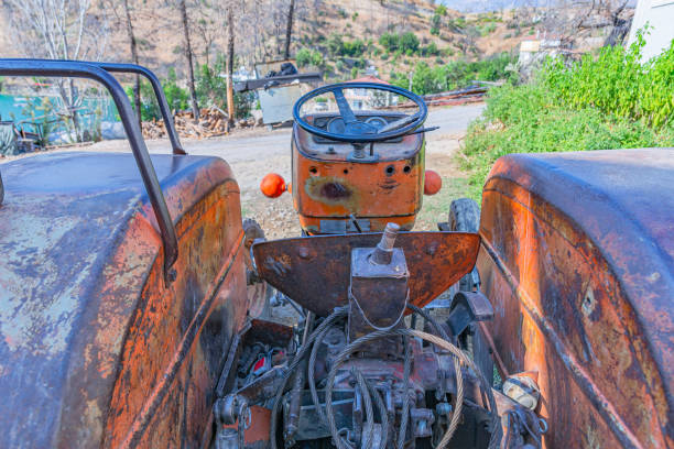 Old Orange Rusty Street Roller - Textured old weathered heavy equipment left out in the elements. Orange peeling paint and rusty parts.