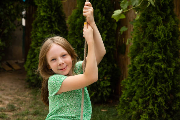 Young Caucasian girl swinging on a rope swing Portrait of active young 7 year's old Caucasian girl swinging on a rope swing cleft lip stock pictures, royalty-free photos & images