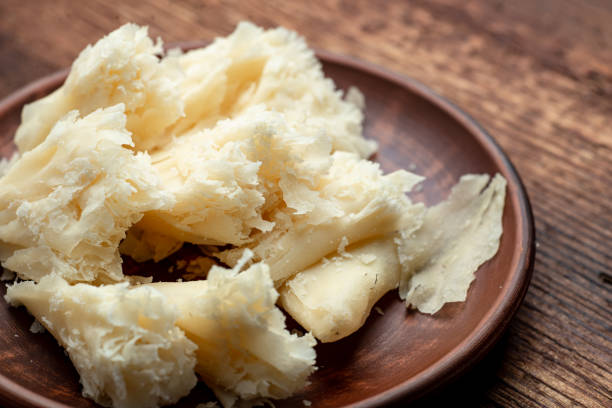 istock Hard cheese sliced chips on a clay plate on a wooden background. 1422317536