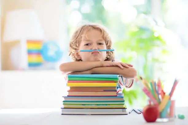 Kids go back to school. Children study and learn for preschool. Little boy of elementary class doing homework. Bedroom with desk, books and globe for young child. Kid learning to read and write.