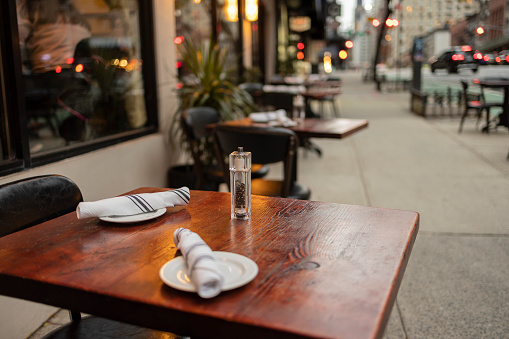Cafe terrace tables with tableware in the evening in Manhattan, NY.