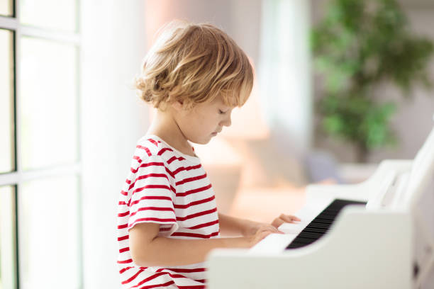 istock Child playing piano. Kids play music. 1422330070