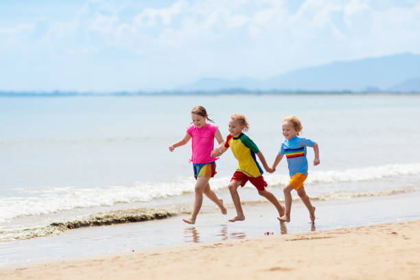 istock Kids playing on beach. Children play at sea. 1422330830