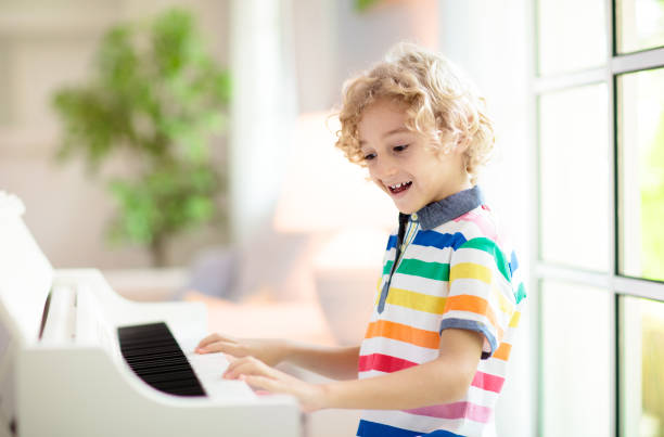 istock Child playing piano. Kids play music. 1422334930