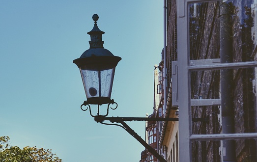 Old vintage lantern lamp post on the sunset sky background