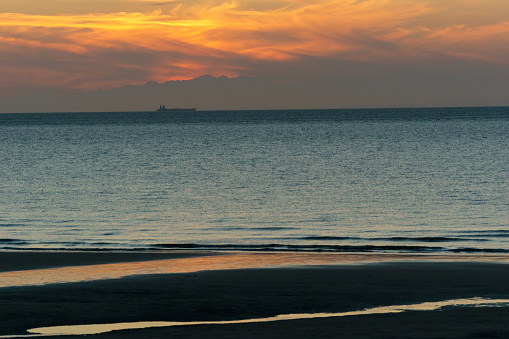 beautiful twilight after sunset on the french opal coast at the north sea with distant ship, Wissant, France