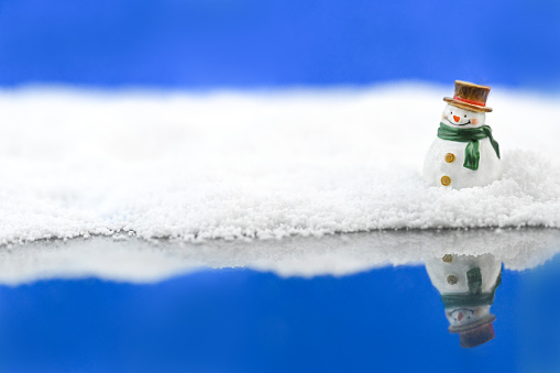Snowman in the snow with reflection
