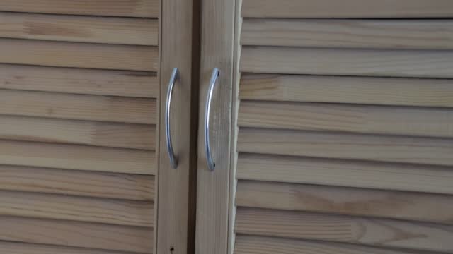 the doors of the blinds of a homemade wooden cabinet