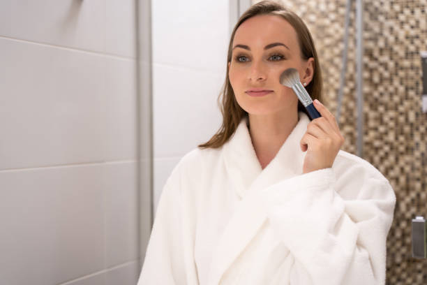 istock Woman puts powder on face blending with cosmetic brush 1422359632