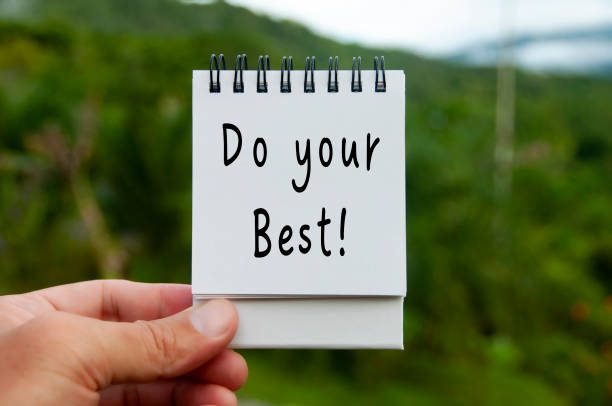 istock Hand holding notebook with do your best text with blurred nature background. Motivational concept 1422363400