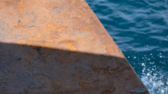 Close-up of a rusty ferry ramp against the water of tropical sea. transportation and travel concept