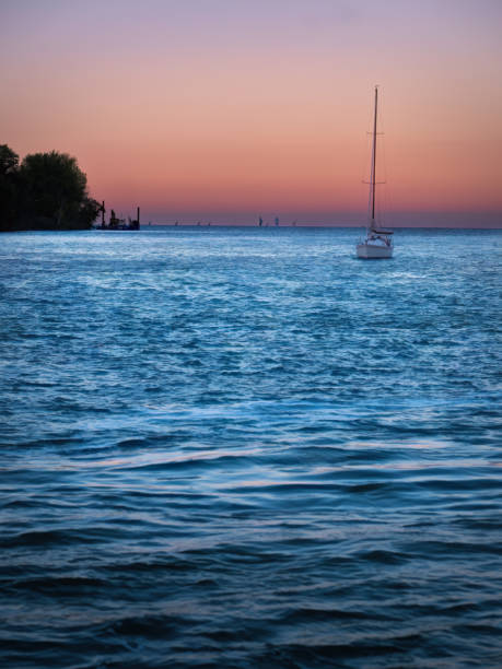 A sailboat on Lake St. Clair which is bordered by Windsor, Ontario and Detroit Michigan