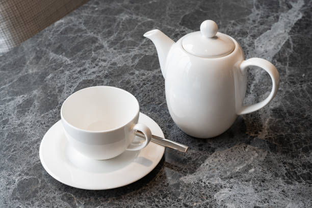 istock White teapot and white cup with teaspoon on stone table 1422390838