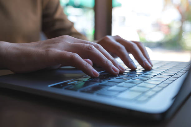 istock Closeup image of hands working and typing on laptop computer keyboard 1422398397