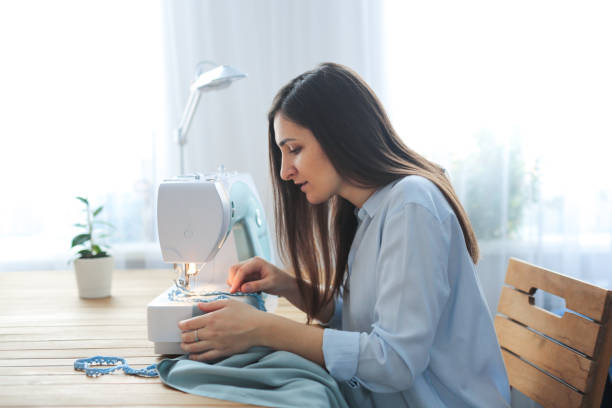 istock craftswoman sews on sewing machine in real room 1422399732