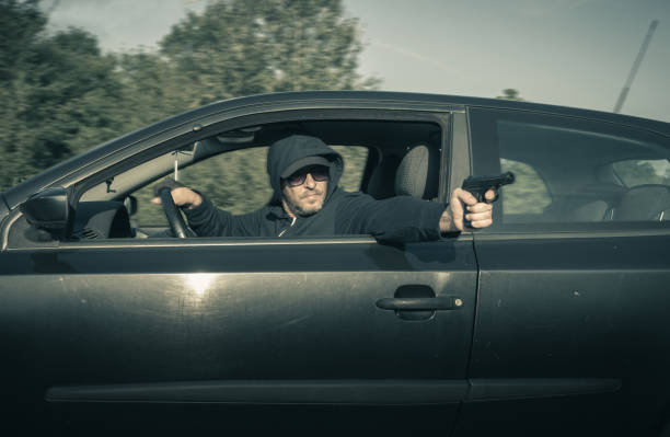 The man was shooting from the car A man fires a gun from the car. machine gun stock pictures, royalty-free photos & images