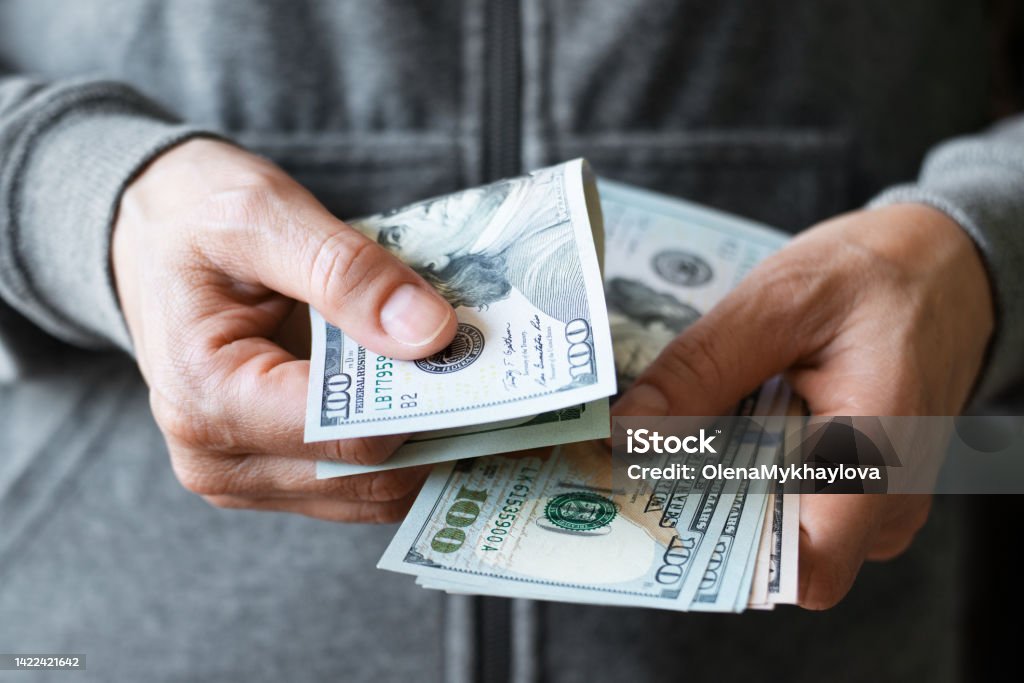 White female model shows dollar bills in her hand closeup front view Paper Currency Stock Photo