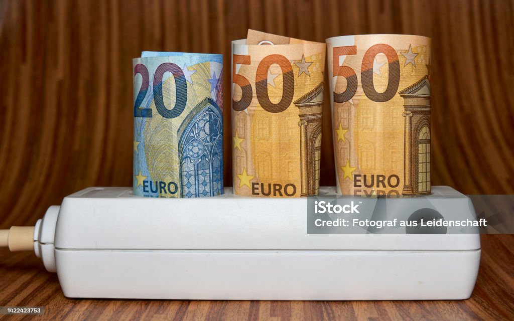 Electric socket with 50 euro bill . Rising electricity prices and costly energy concept for families and businesses Electric socket with 50 euro bill . Rising electricity prices and costly energy concept for families and businesses. Aiming Stock Photo
