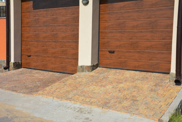 istock Close up on modern house two garage doors entrace with rain gutter pipes and pavement. 1422424552
