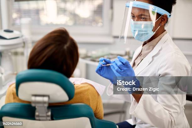 African American Dentist During Appointment With Her Patient At Dental Clinic Stock Photo - Download Image Now