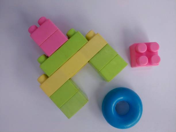 Colorful block puzzle toys arranged like a tower With one piece loose and a blue circle