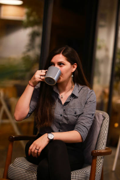 istock Young happy woman drinking coffee and relaxing in a cafe. 1422439821