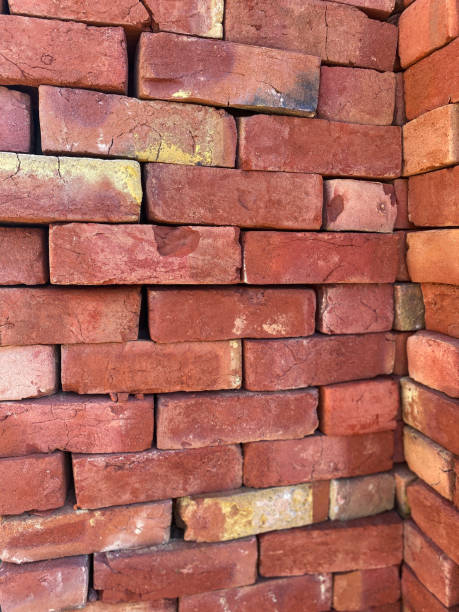 istock Full frame image of pile of handmade red bricks stacked up in Indian building site, rustic clay bricks, wall on construction site, focus on foreground 1422440045
