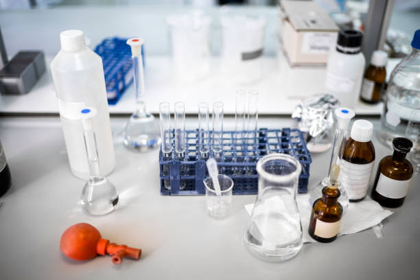 Close up on a few bottles and test tubes seen in a clean room during laboratory research in a pharmaceutical industry.