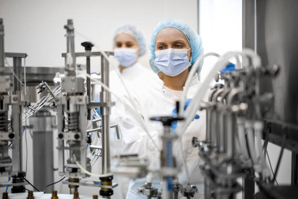istock Two fully equipped coworkers in protective workwear seen in a pharmaceutical laboratory 1422442024