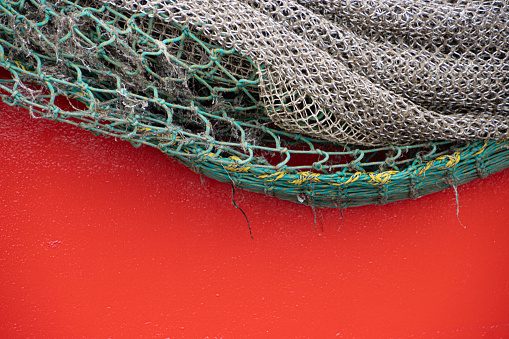 Fishing net hanging over red background