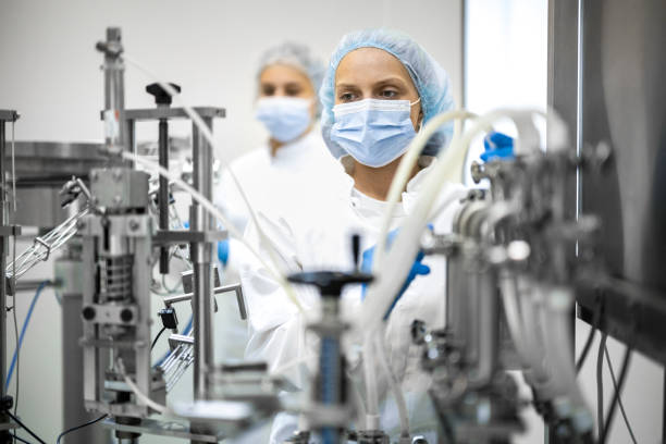 istock Fully equipped technicians in protective workwear seen in a pharmaceutical laboratory 1422443070