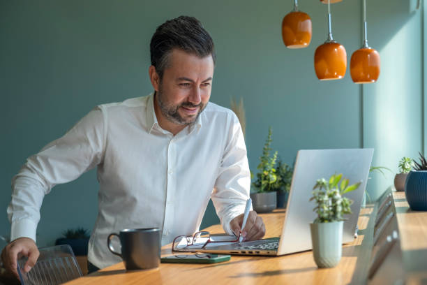 istock Handsome businessman taking notes on paper while having video call in office 1422444197