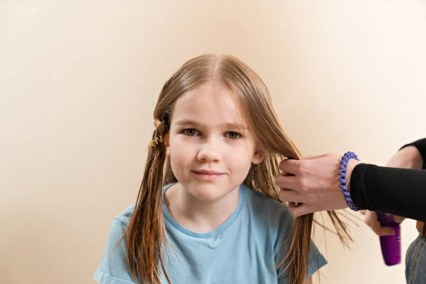 istock Mom combs, shares her daughter's wet hair before cutting 1422446192