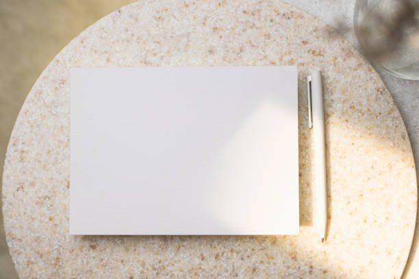 istock Mockup paper poster card with pen on stone round table 1422446214