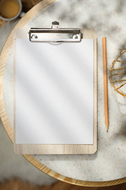 istock mockup blank clip paper board top view on stone round table with sunlight 1422446418