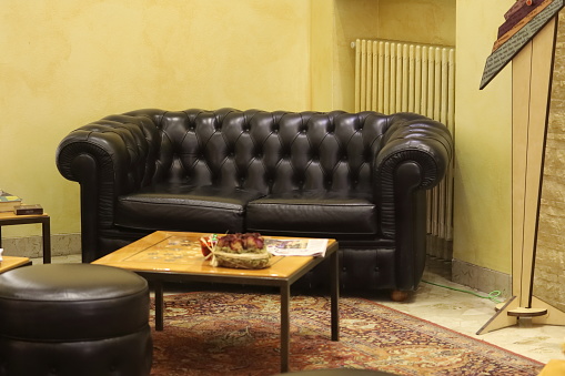 Traditional Chesterfield sofa couch with a small vintage square table