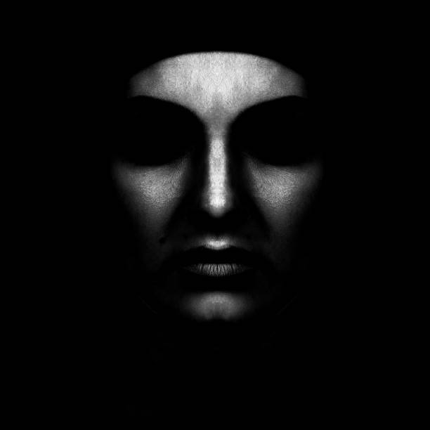 istock Abstract and scary looking woman face silhouette hiding in shadow 1422448834