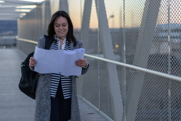 istock portrait of a female engineer wearing a backpack looking at bridge plans 1422451907
