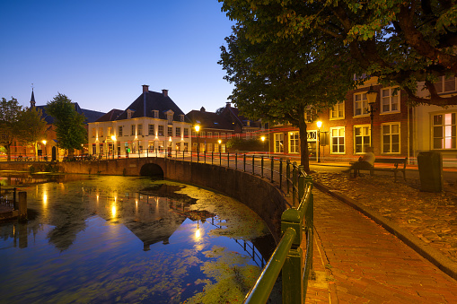 Architecture in the Netherlands. Modern and old buildings. Canals and bridges. Architectural landscape. Evening lighting in the city. Postcard view.