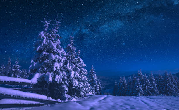 Fairytale carpathian frozen highlands covered with snow. Night starry sky with milky way. Winter time. Ukraine, Europe.