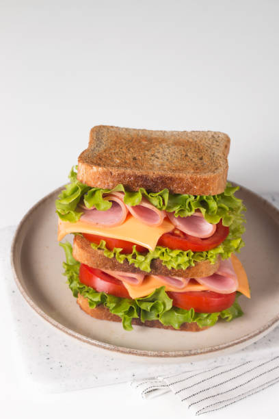 istock Club sandwich with ham, cheese, tomato and lettuce. 1422461123