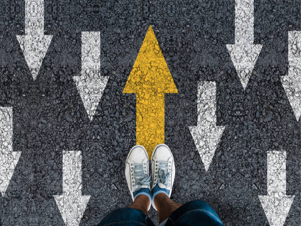 istock man sneakers on asphalt and opposing direction arrows 1422463615