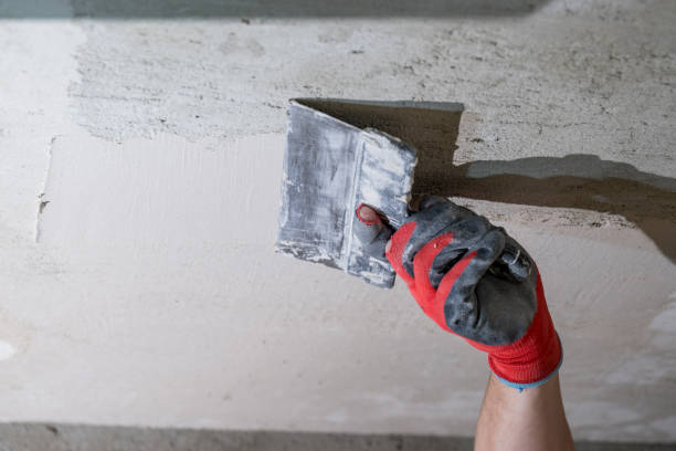 istock The master in gloves aligns the ceiling with lime plaster close up. 1422463704