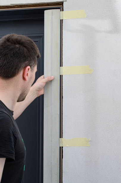 istock Checking the door frame for evenness of the surface after installation using a metal rule. 1422463986