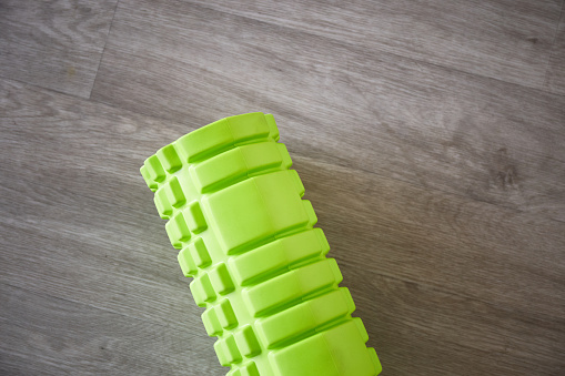 Green MFR sport roller for self-massage. Home fitness accessories. Flexibility and mobility, body strength