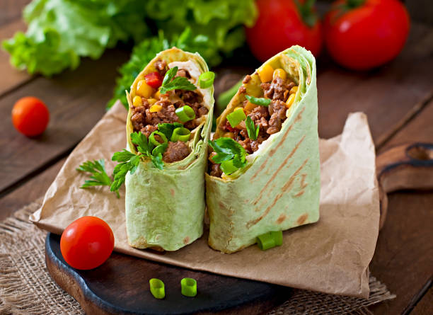 istock Burritos wraps with minced beef and vegetables on a wooden background 1422470026