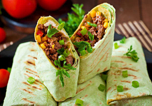 istock Burritos wraps with minced beef and vegetables on a wooden background 1422470181
