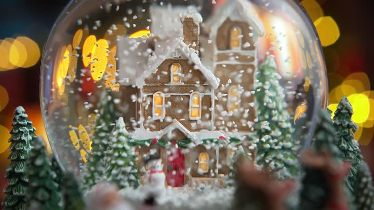 Christmas Snow Globe with Snow Falling in Slow Motion and Lights Turning On  - Flickering Fire in the Background