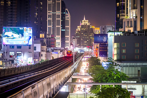 Bangkok, Thailand - September 11, 2019: BTS Sky Train is running in downtown pass through skycrapers business buildings at night