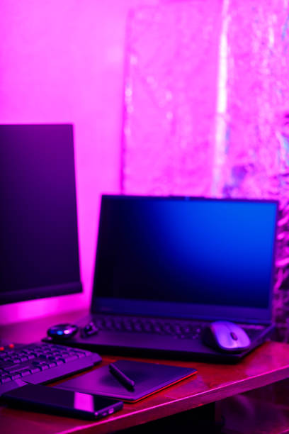 istock Workplace of a graphic designer and creative retoucher. Graphic tablet, smartphone and computer equipment in neon light. Workspace of creative designer with tablet and stylus 1422473984